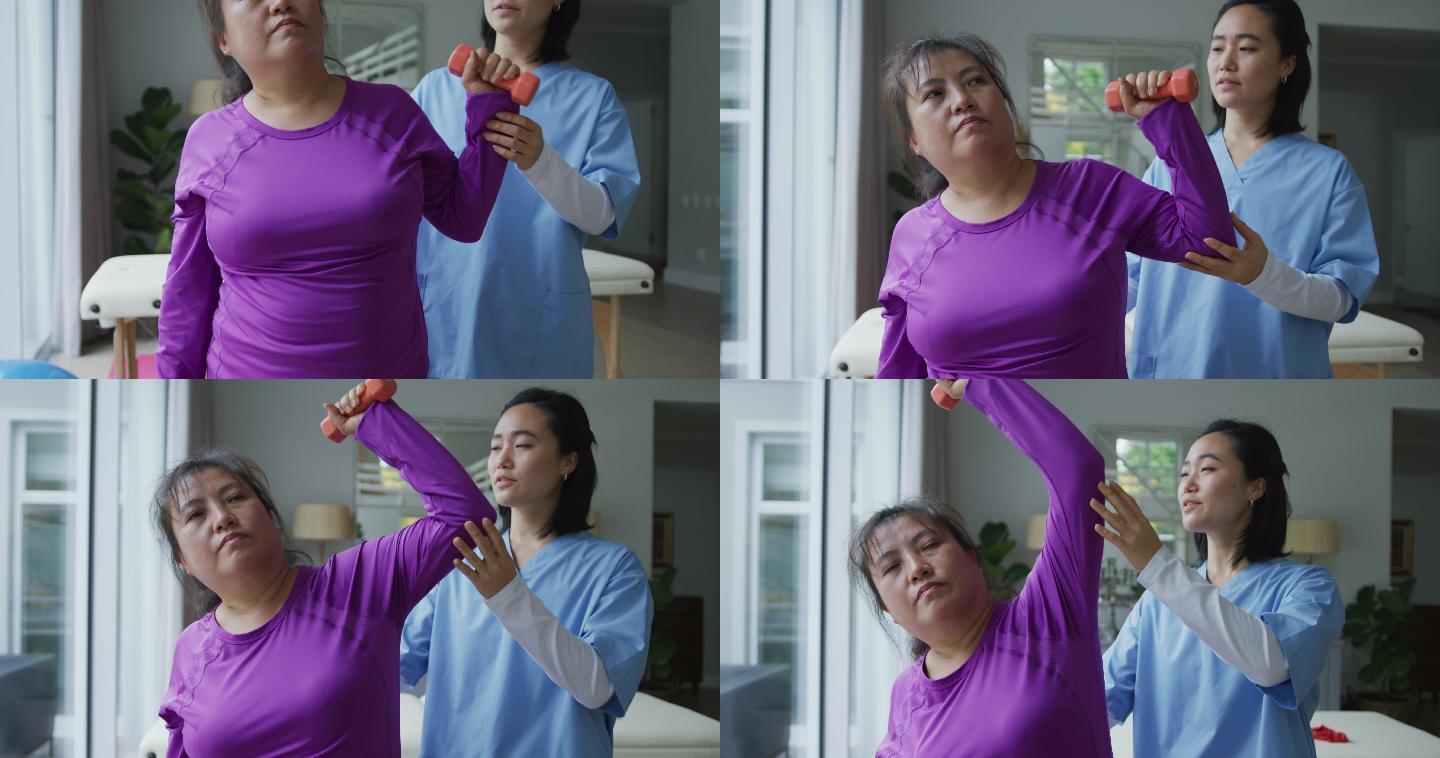 亚洲女性理疗师帮助女性病人在手术中用哑铃锻炼手臂