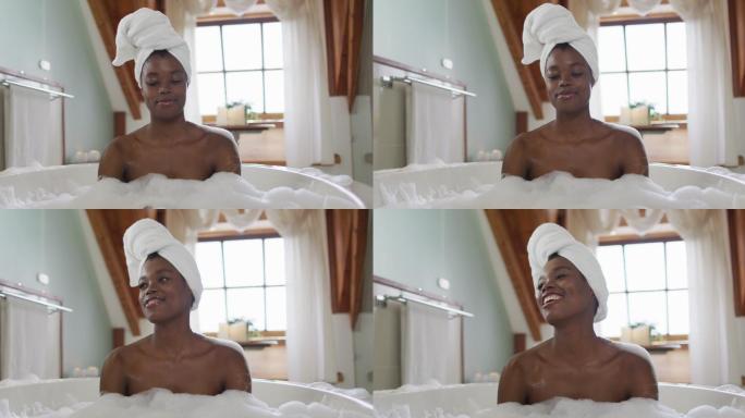 快乐的非洲裔美国人有吸引力的女人放松在浴室的泡沫浴