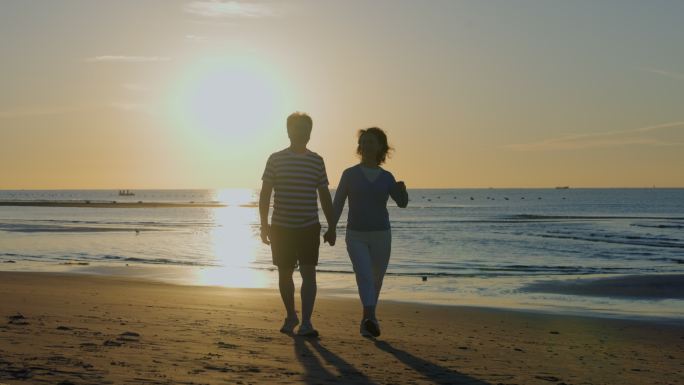 快乐的老年夫妇在海边散步