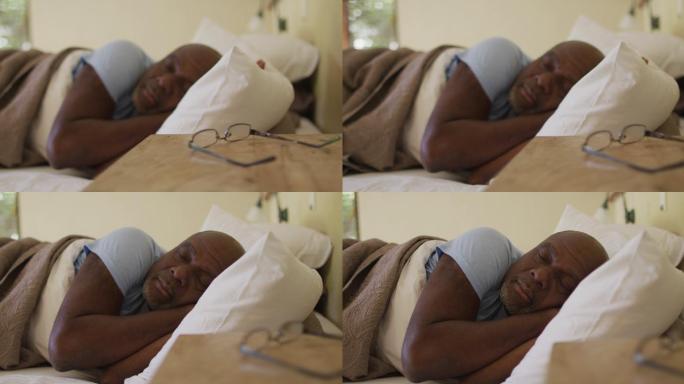 疲惫的非洲裔美国老人躺在床上睡觉，眼镜放在床头柜上