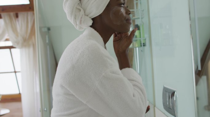 非裔美国美女在浴室里涂面霜