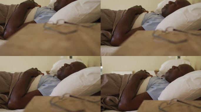 疲惫的非裔美国老人躺在床上睡着了