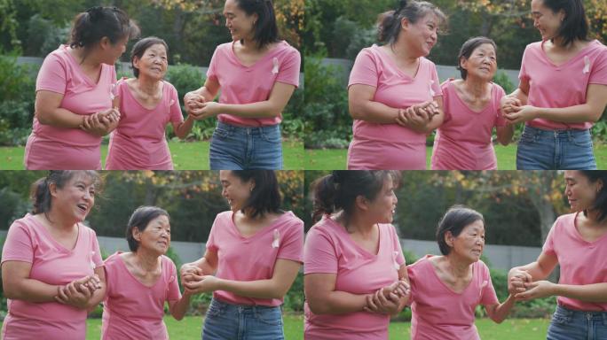 快乐的亚洲成年孙女和母亲牵着奶奶的手在花园里散步