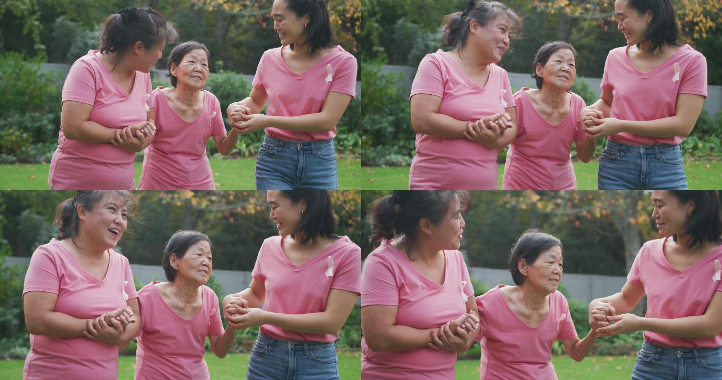快乐的亚洲成年孙女和母亲牵着奶奶的手在花园里散步