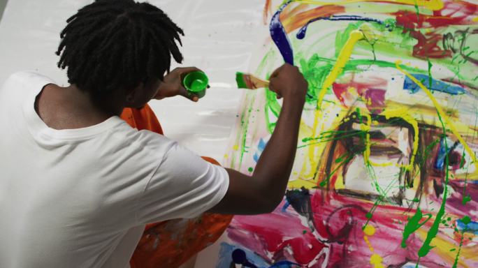 头顶视图的非裔美国男性艺术家倒油漆与画布上的画笔