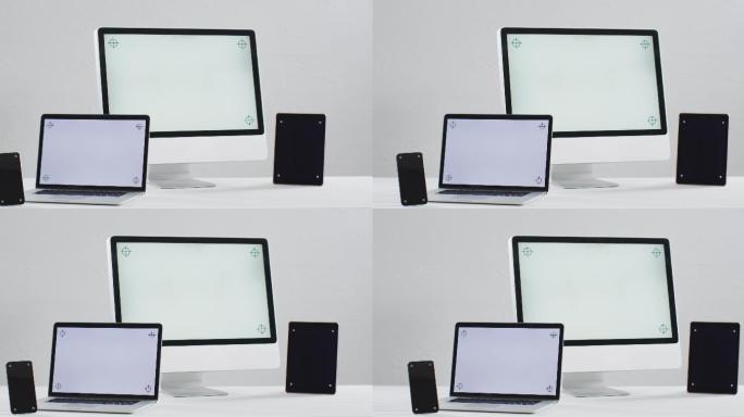笔记本电脑、智能手机、平板电脑和电脑的视频放在白色的桌子上，办公室里有拷贝空间