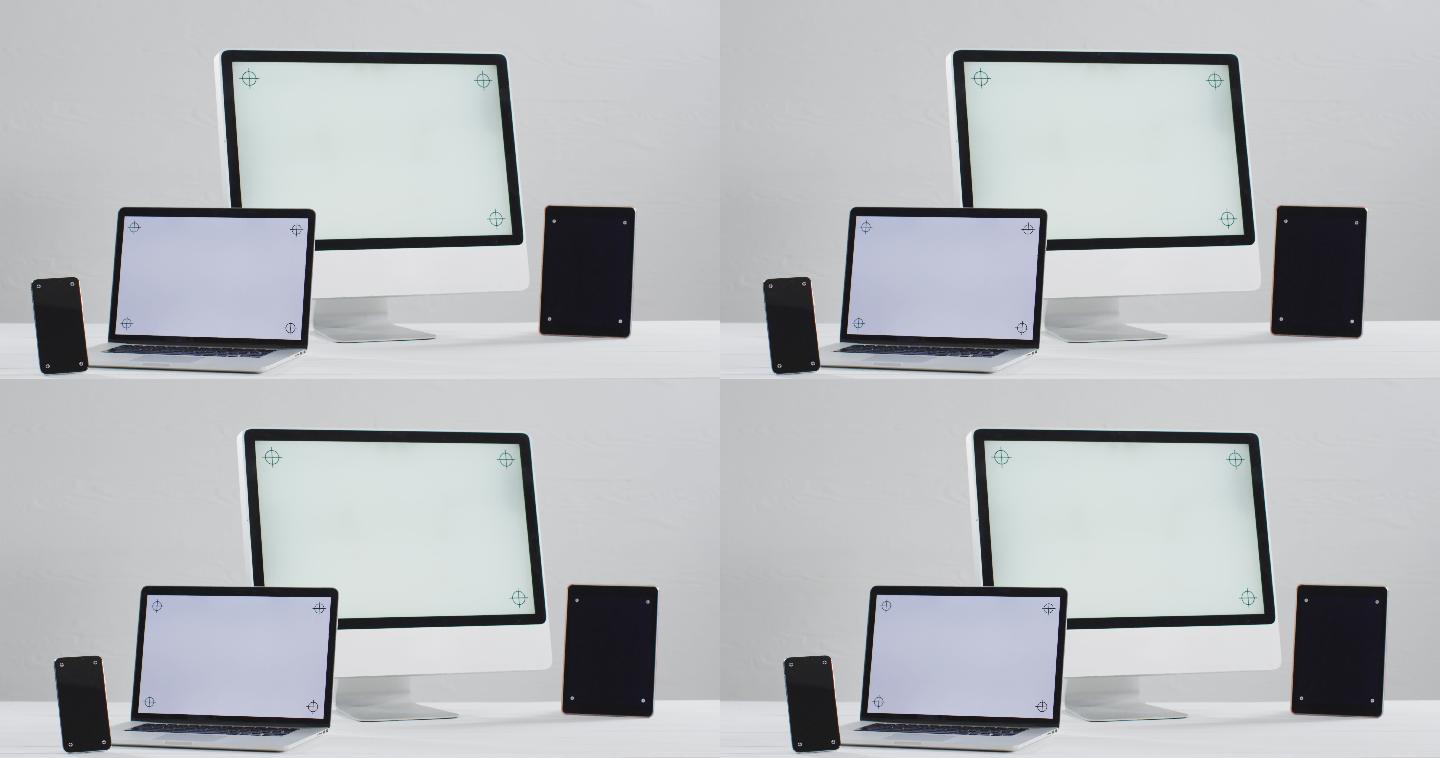 笔记本电脑、智能手机、平板电脑和电脑的视频放在白色的桌子上，办公室里有拷贝空间