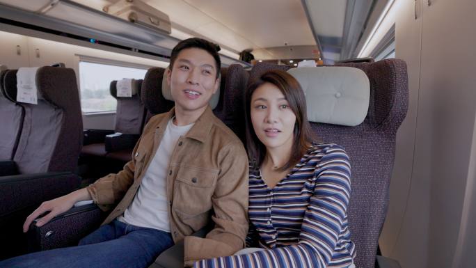高铁车厢内幸福的年轻伴侣