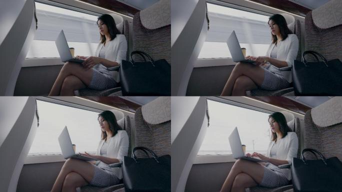 年轻商务女士在高铁上使用笔记本电脑
