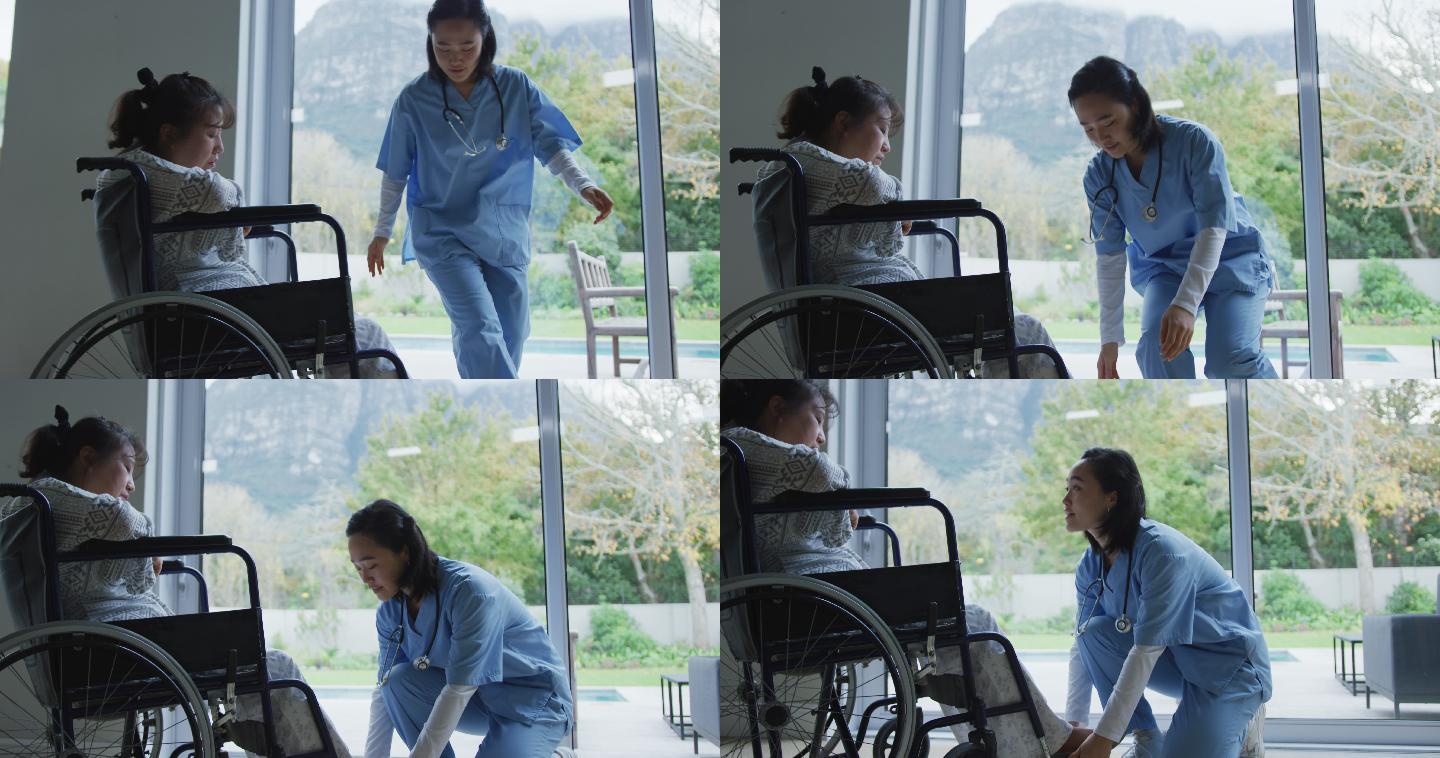 亚洲女医生与轮椅上的女病人交谈，并在医院安排她的脚