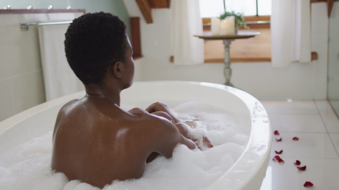 非洲裔美国人有吸引力的女人放松在浴室的泡沫浴