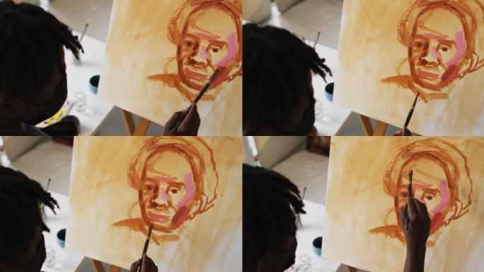 非裔美国男性艺术家戴着面具在画布上绘画在艺术工作室
