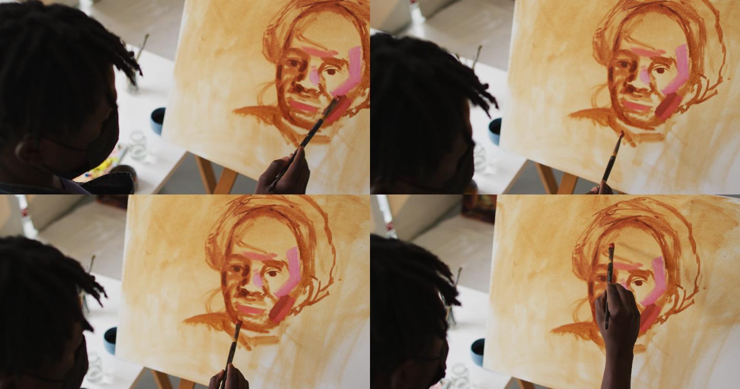 非裔美国男性艺术家戴着面具在画布上绘画在艺术工作室