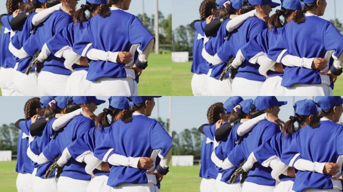 女棒球队员们互相抱着胳膊站在球场上