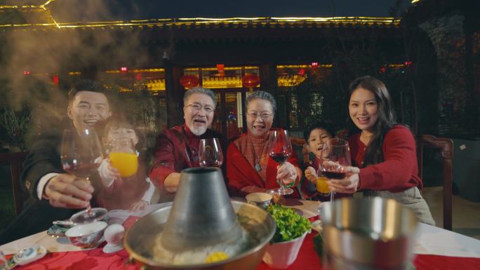 东方家庭在中式庭院内举杯庆祝新年