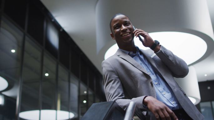 非裔美国商人在现代办公大厅使用智能手机
