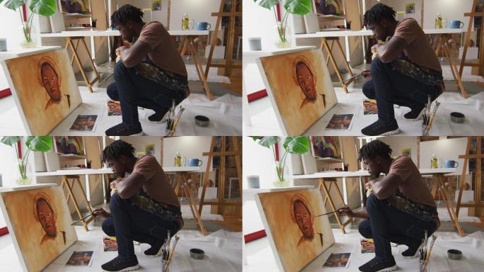 侧视图的非裔美国男性艺术家穿着围裙在画布上画在艺术工作室