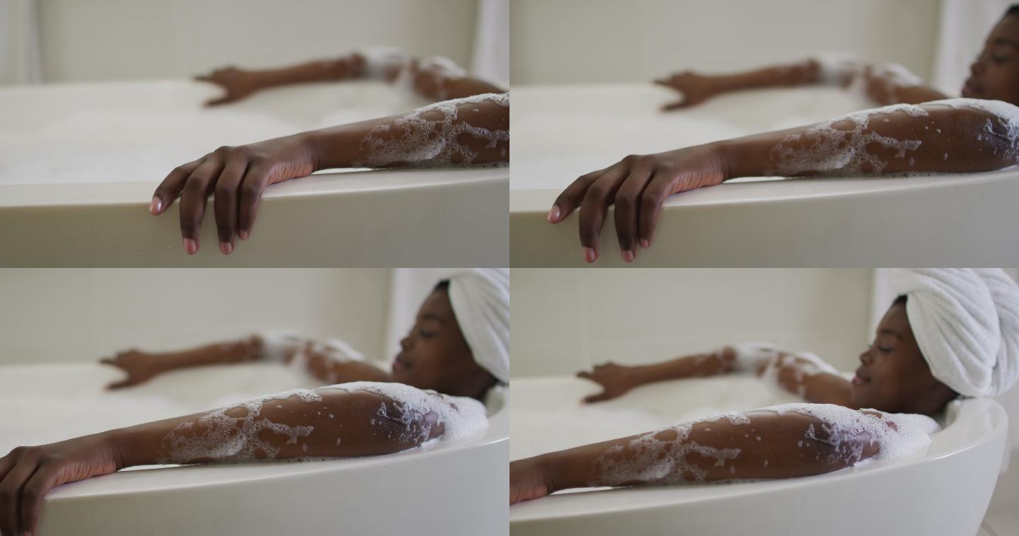 非裔美国人有吸引力的女人放松在浴室的泡沫浴
