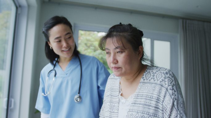 微笑的亚洲女医生在医院帮助快乐的女病人用步行架行走