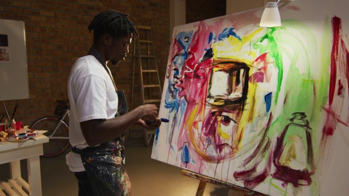 非裔美国男性艺术家在艺术工作室用智能手机拍他的画