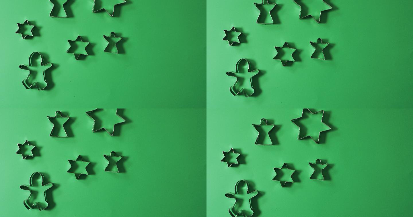 天使，姜饼人和星形饼干刀具和复制空间的绿色背景