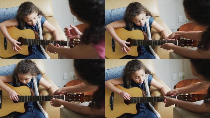 快乐的混血母亲和女儿一起弹吉他