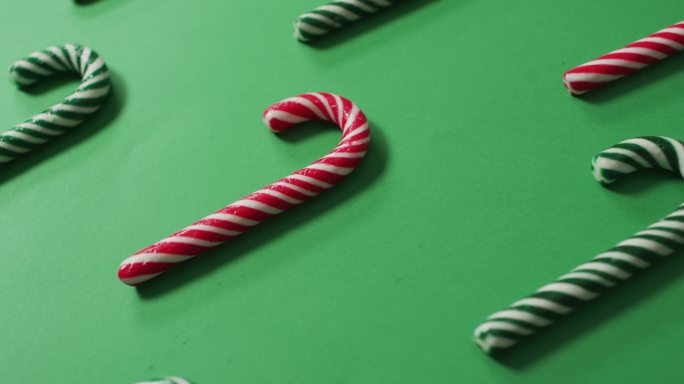 红色和绿色条纹糖果手杖在绿色的背景