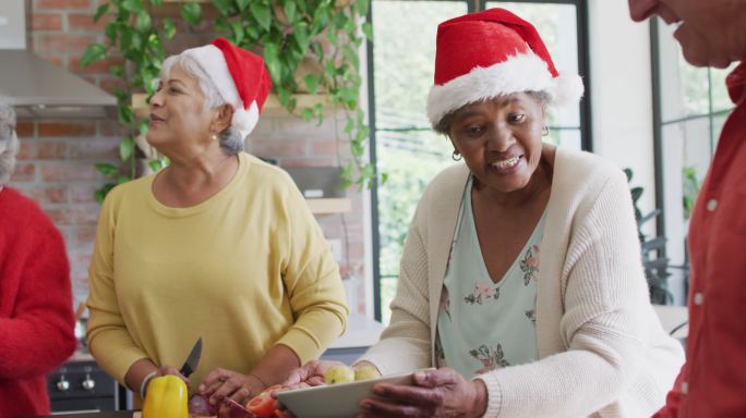 圣诞节期间，一群快乐的不同年龄的朋友在厨房里一起烹饪