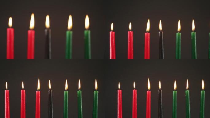 在黑色的背景下，万圣节的绿色、黑色和红色蜡烛的组成