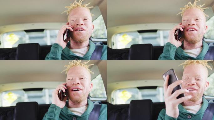 快乐的白化非裔美国人留着脏辫坐在车里用智能手机聊天