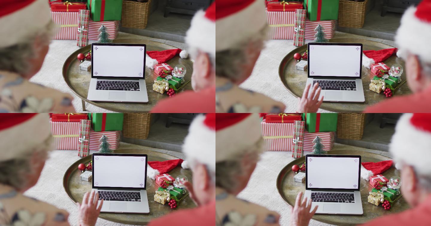 白种人老夫妇戴着圣诞老人帽，在圣诞节期间用笔记本电脑进行视频通话，还有复印空间