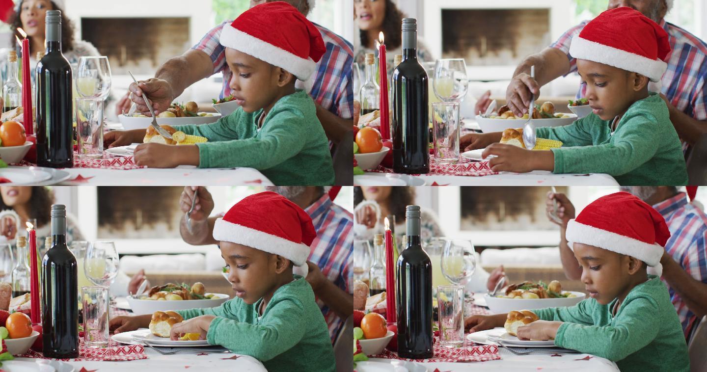 快乐的非裔美国人多代家庭戴着圣诞帽庆祝大餐