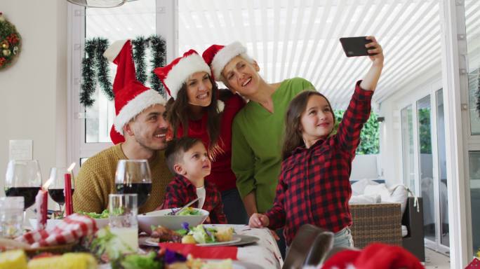 快乐的白种人多代家庭戴着圣诞帽自拍