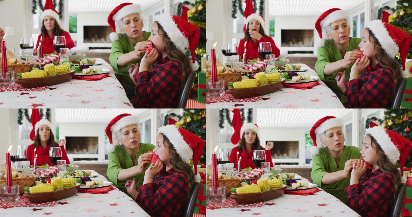 快乐的白人奶奶在圣诞餐桌上给孙女擦嘴