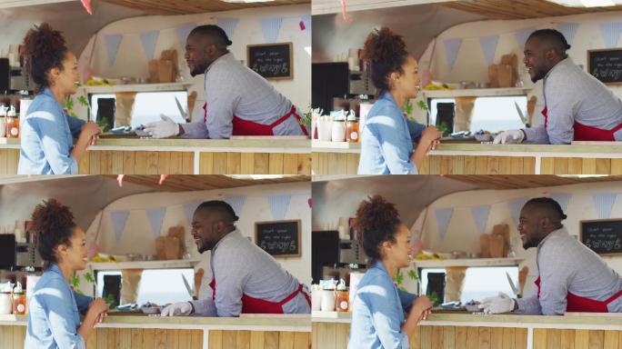 快乐的非裔美国男性餐车老板交谈柜台微笑的女性顾客