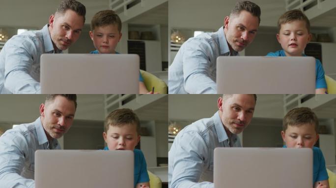 白人父亲带着儿子坐在家里用笔记本电脑学习