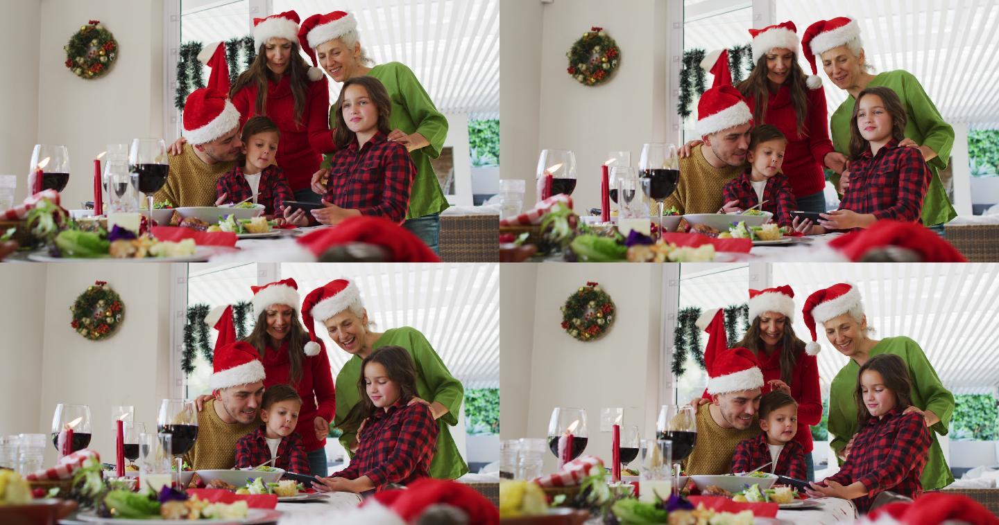 幸福的白种人多代家庭戴着圣诞帽看着智能手机