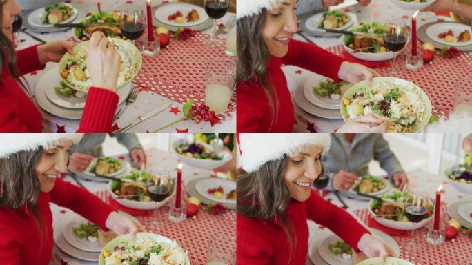 快乐的白种女人戴着圣诞老人帽在盘子里放沙拉