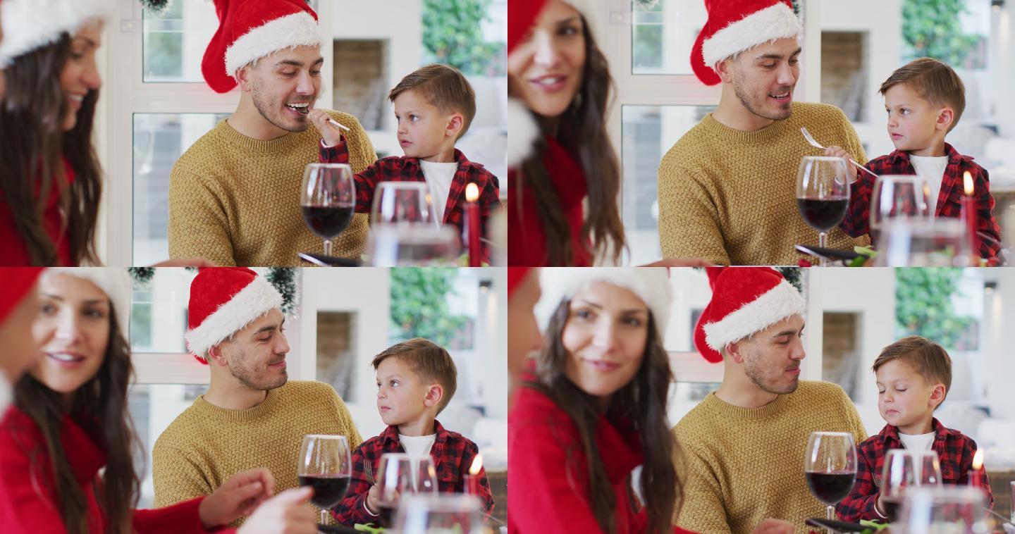 一个白人儿子在圣诞大餐上用叉子给他的父亲吃东西