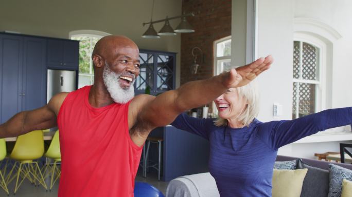 混合种族老年夫妇在家中一起做伸展运动