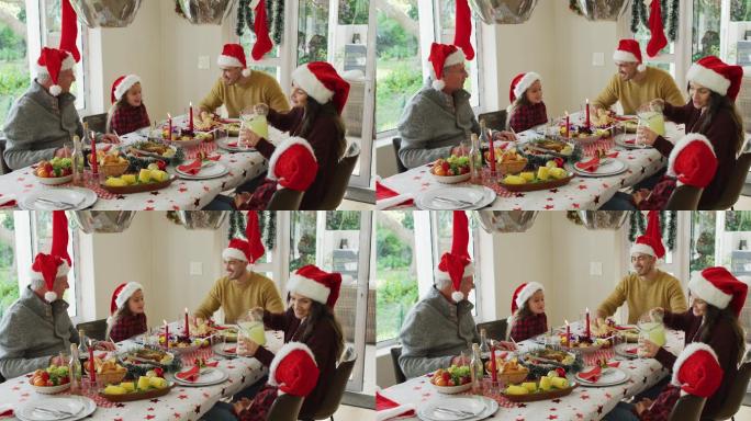 幸福的白种人多代家庭戴着圣诞帽，吃着圣诞大餐