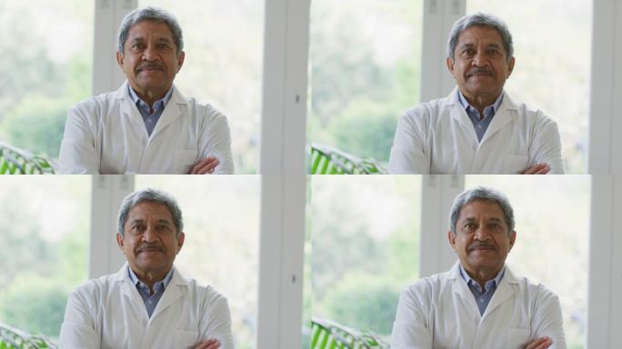 非裔美国男性高级医生双臂交叉微笑在家里的肖像