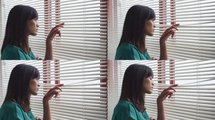 在现代牙科诊所，一个混血儿女性病人独自透过窗户看