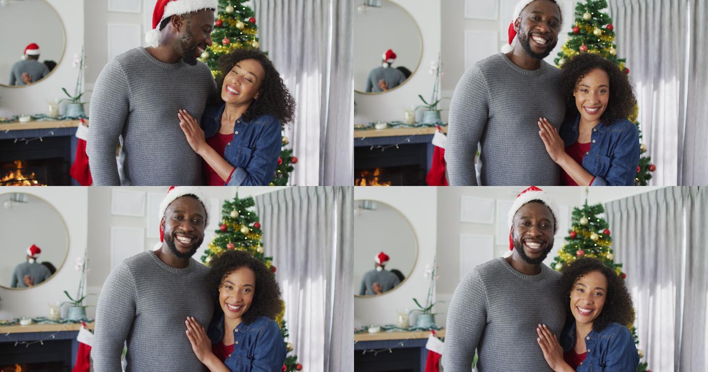 快乐的非裔美国夫妇拥抱着，看着镜头，背景是圣诞装饰