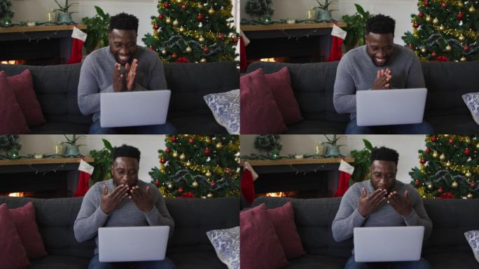 微笑的非裔美国人在视频通话，送吻，背景是圣诞装饰
