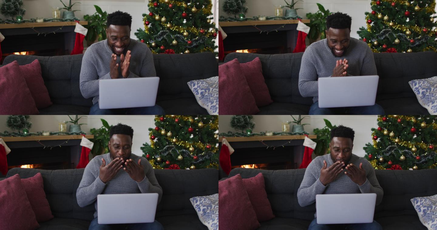 微笑的非裔美国人在视频通话，送吻，背景是圣诞装饰