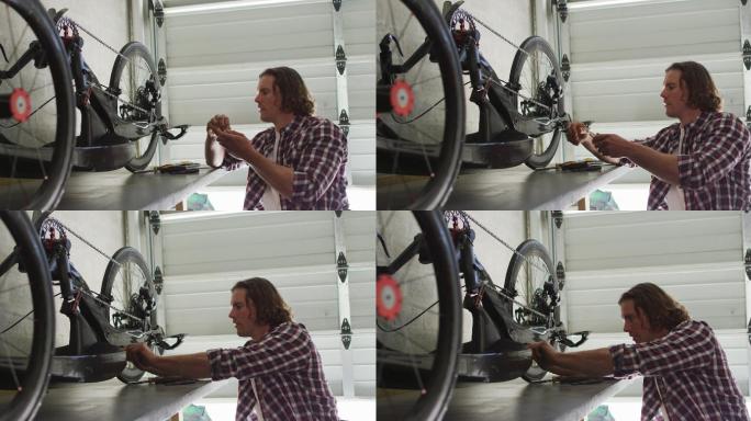 集中高加索人修理自行车使用工具在车库