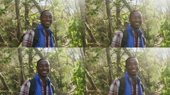 微笑的非洲裔美国人的肖像在森林徒步旅行在农村