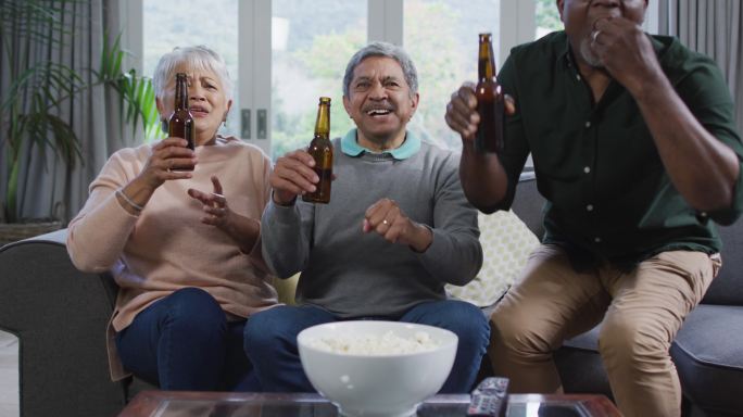 快乐的混合种族老年夫妇和非洲裔美国朋友喝啤酒，有乐趣