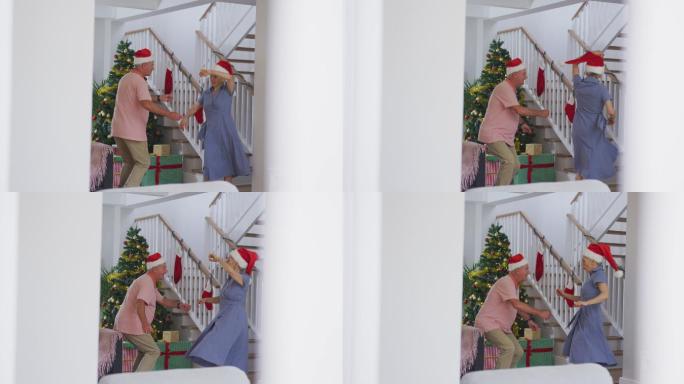 快乐的白种人老夫妇戴着圣诞帽，在圣诞节跳舞